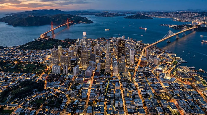 A beautiful evening skyline view of the San Francisco Bay Area, illustrating the bustling city lifestyle where residents seek premium home wellness and massage chair solutions