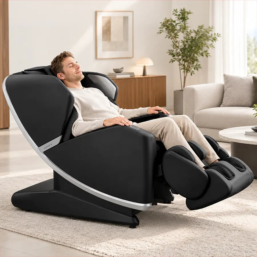A man reclining in a modern black massage chair with silver trim in a bright, contemporary living room.
